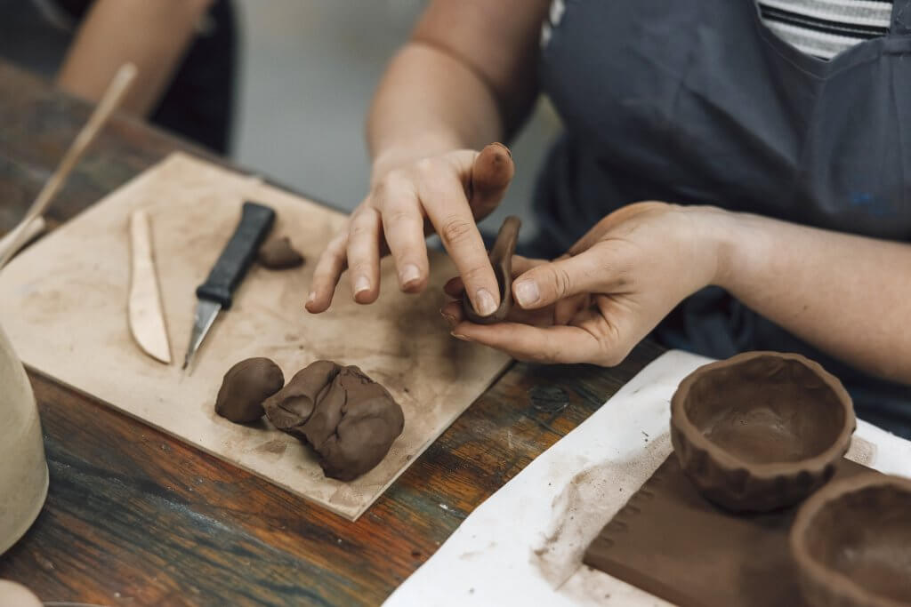 Close-up view of female hands moulding clay