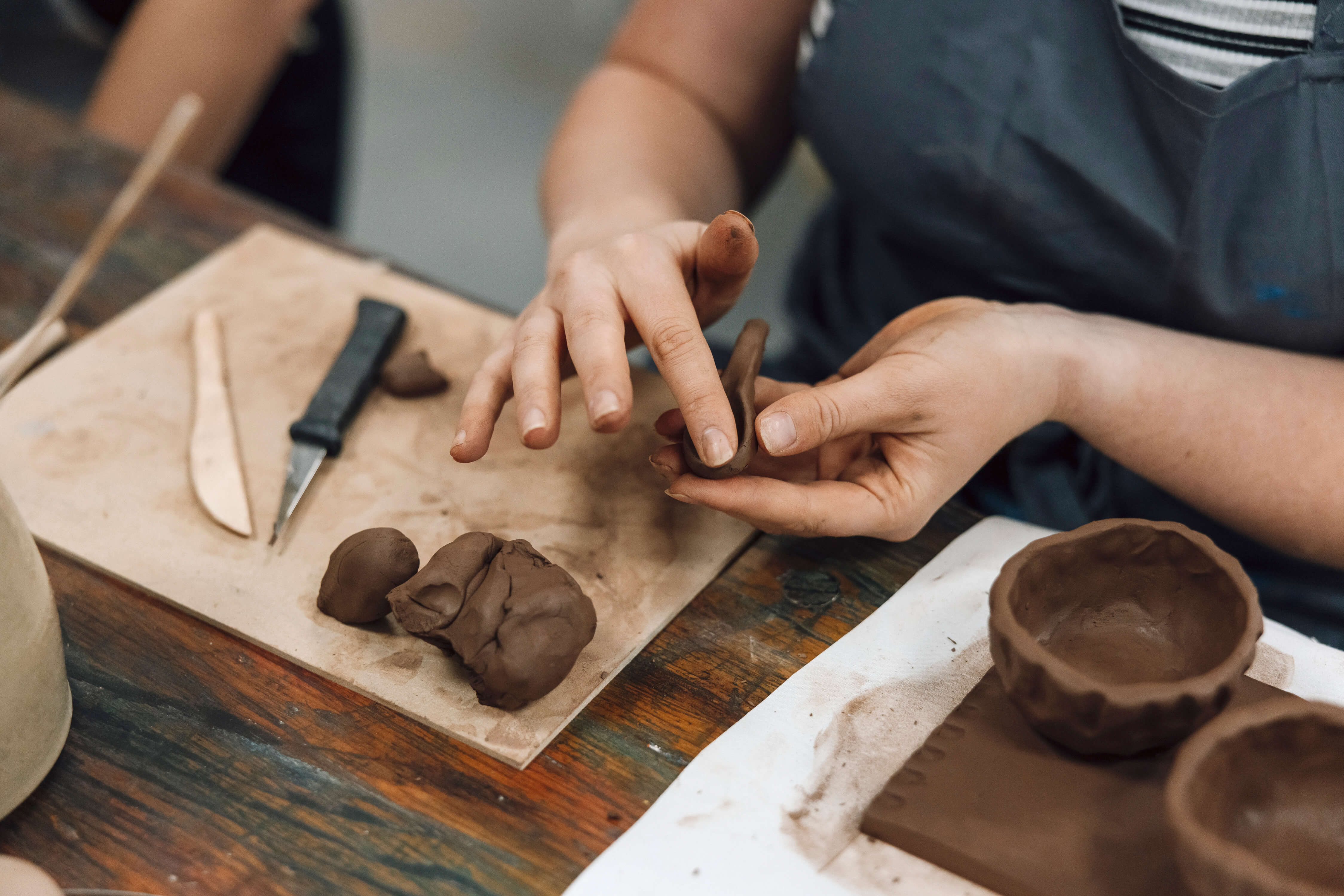 Close-up view of female hands moulding clay