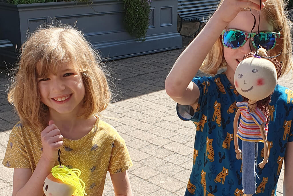 Two young girls with their hand-crafted puppets
