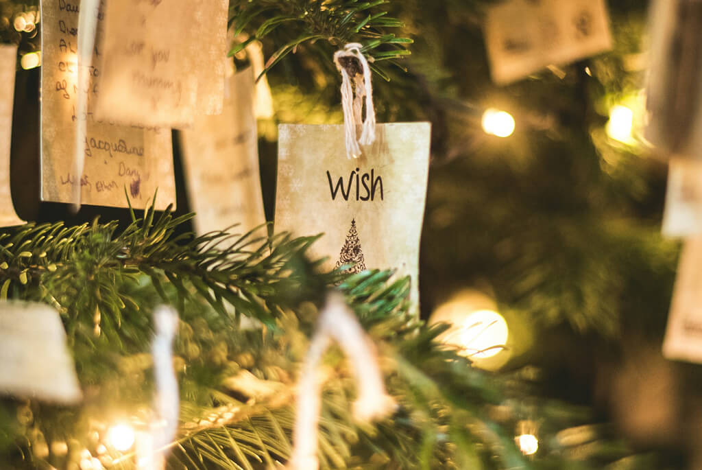 Christmas tree branches decorated with lights and gift tags