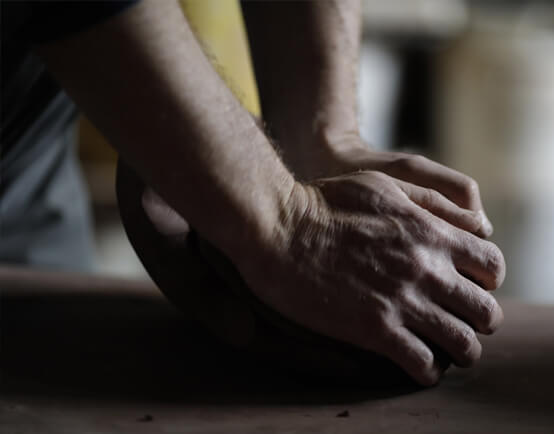 Man's hands working a lump of clay
