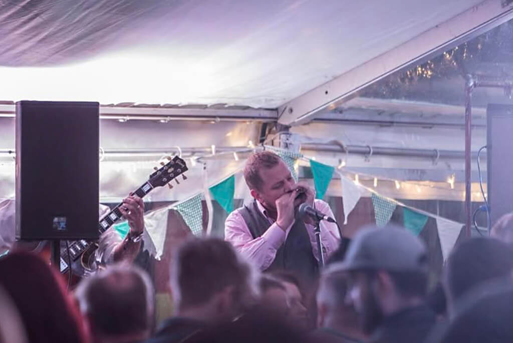 Man playing harmonica on stage at a music event