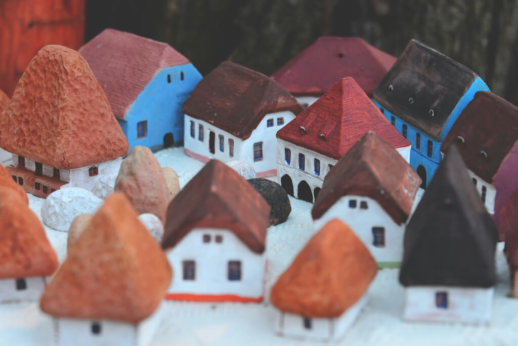 Collection of small, colourful clay houses in white, with red and brown roof tiles