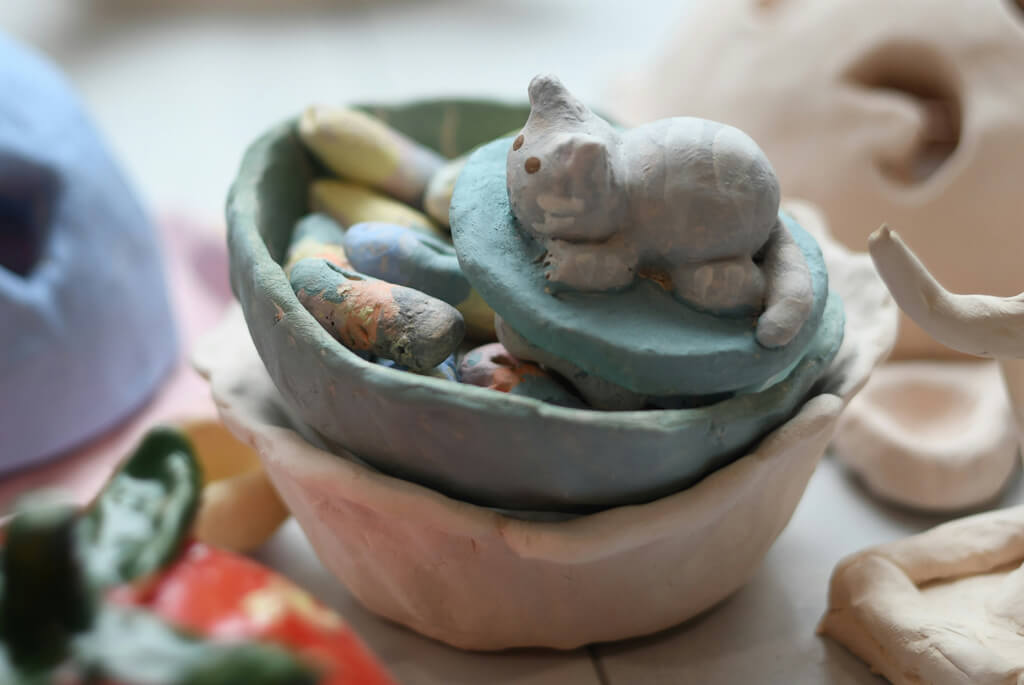 Child's model of a cat in a basket, fashioned out of clay