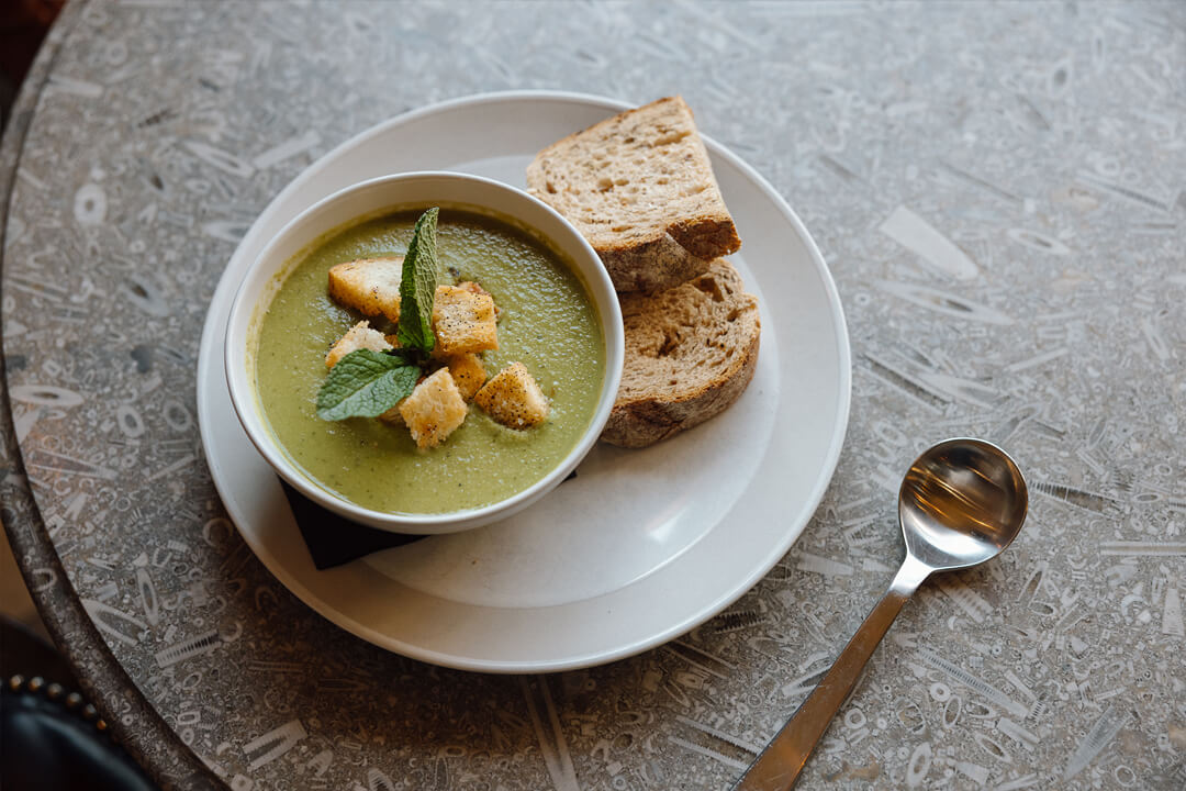 Bowl of vegetable soup with croutons and bread