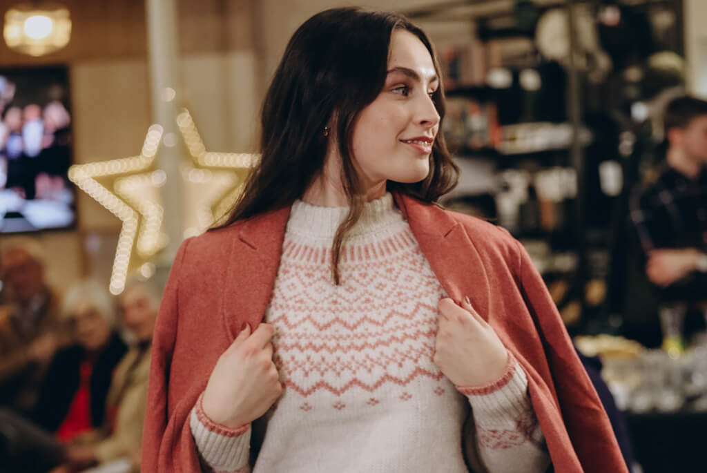 Women with dark hair modelling a rose pink coat and cream jumper