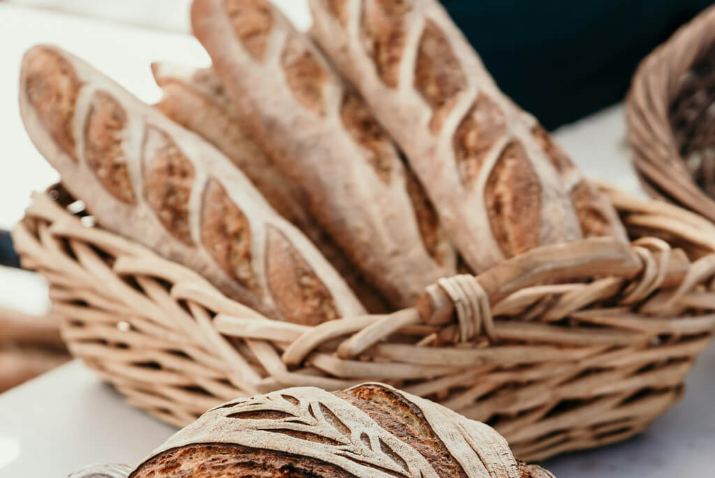 Brown baguette bread in a willow woven basket