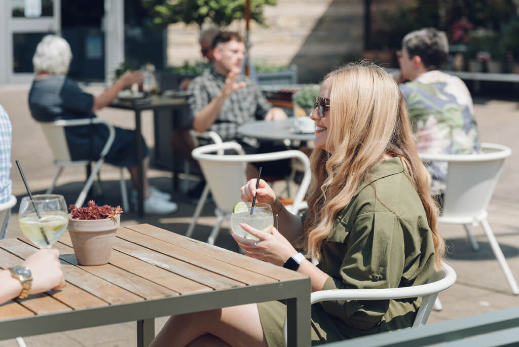 Young woman sipping a drink in the sunshine