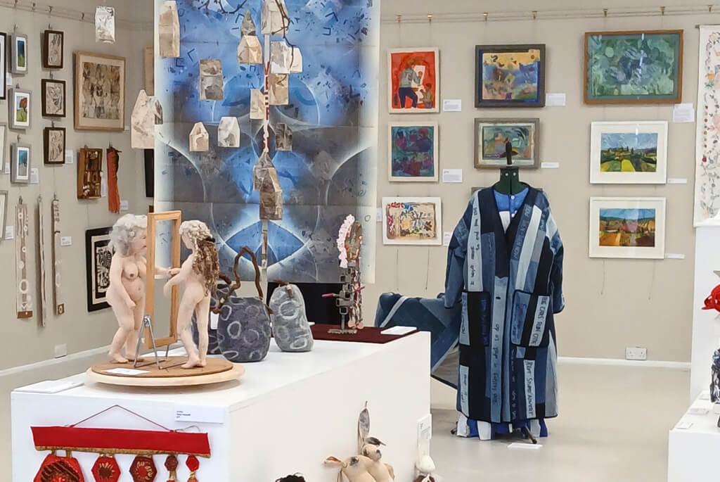 Textile exhibition of framed artwork, clothing, sculpture and wall hangings
