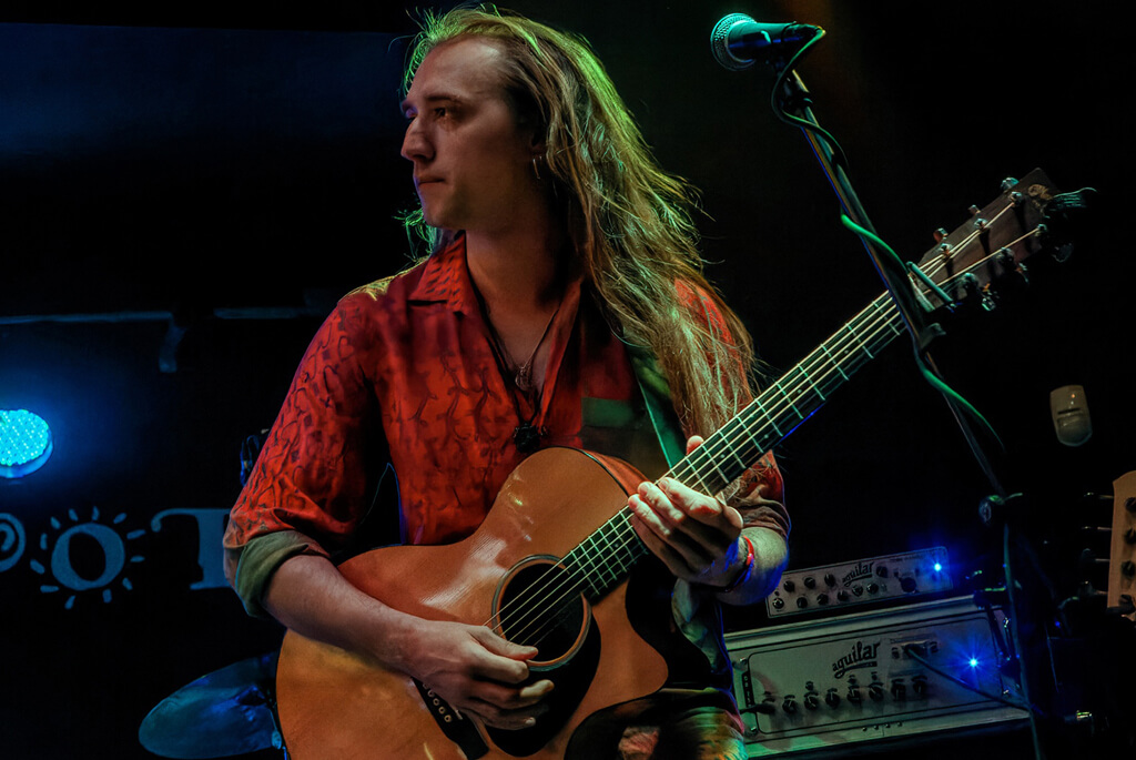 Young male musician with acoustic guitar