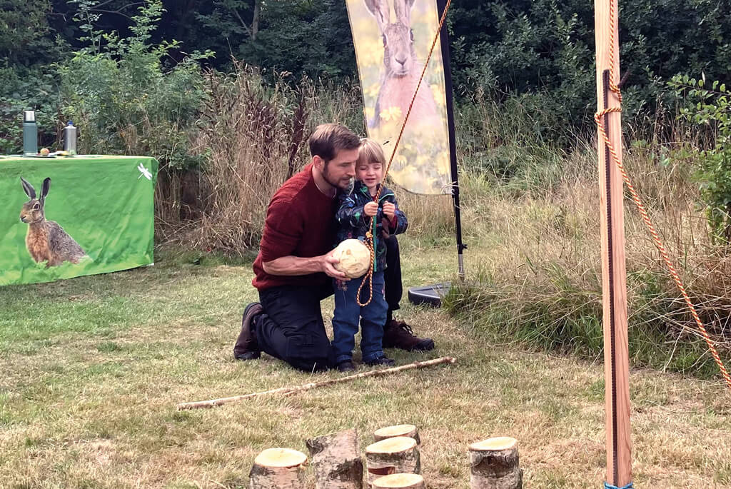 Father and young daughter playing a ball game in a field