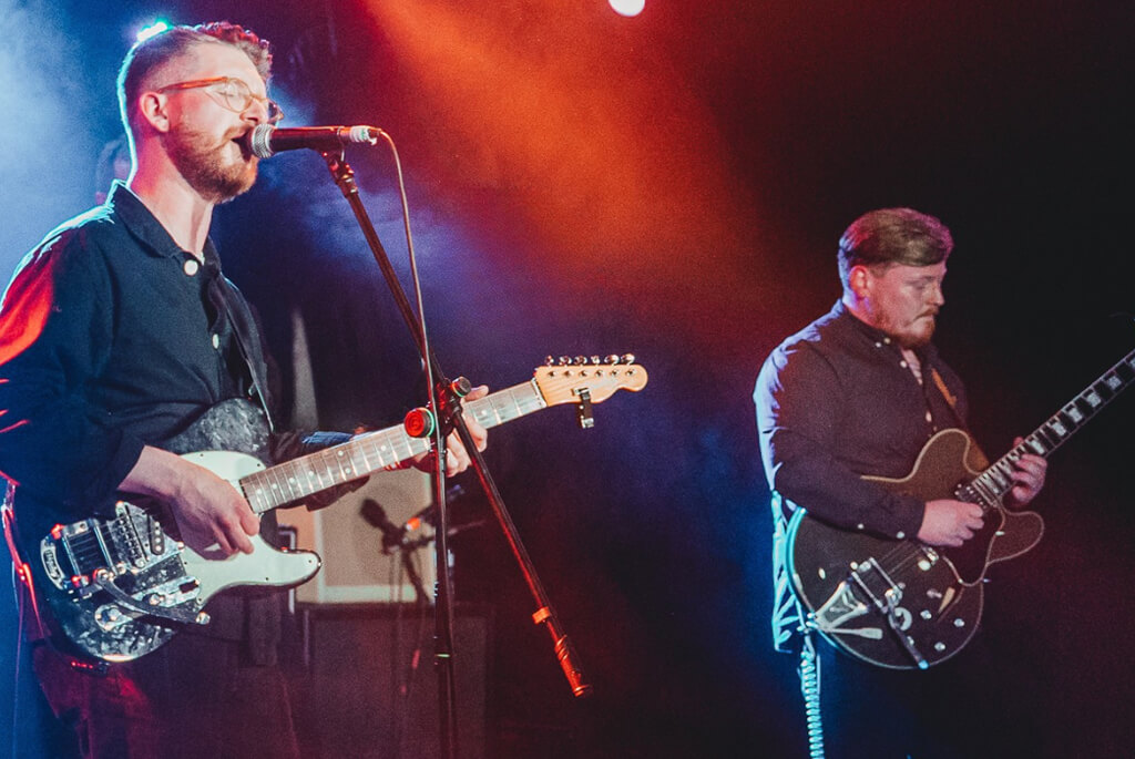 Two male guitar and vocals musicians on stage