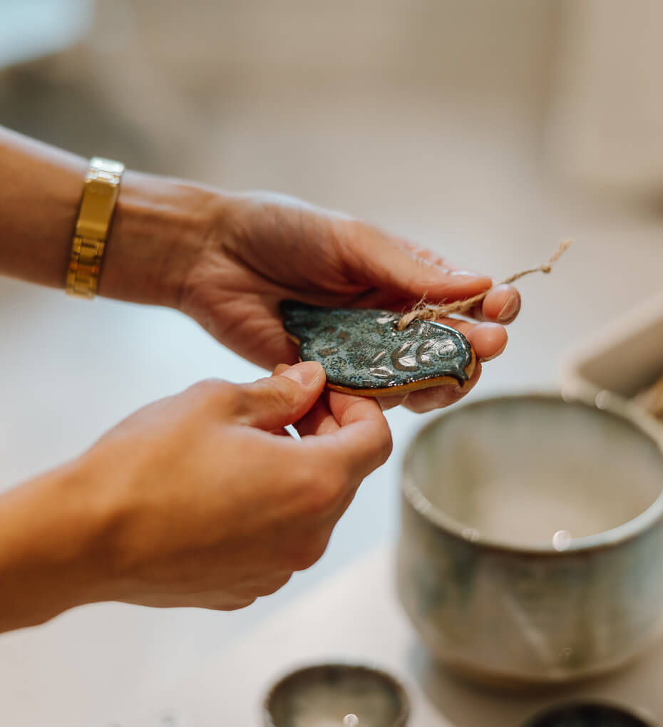 Female hands holding handcrafted pottery bird decoration