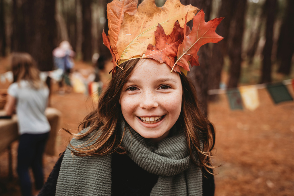 Girl with autumn leaf homemade crown, in the woods