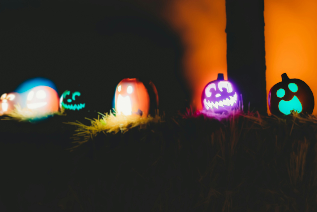 Row of little pumpkins with coloured lights inside