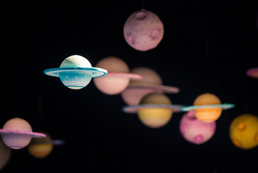 PLanets made from coloured clay. floating against a dark background