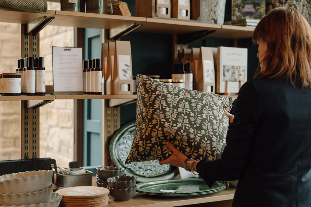 Woman looking at cushion in lifestyle shop