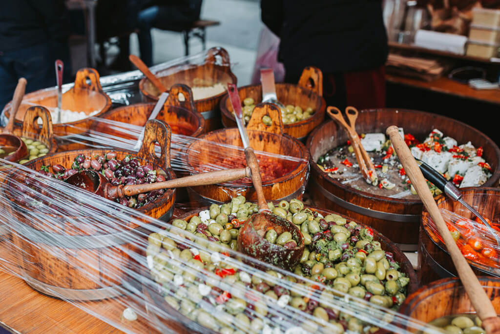 Market stall with wooden tubs of olives